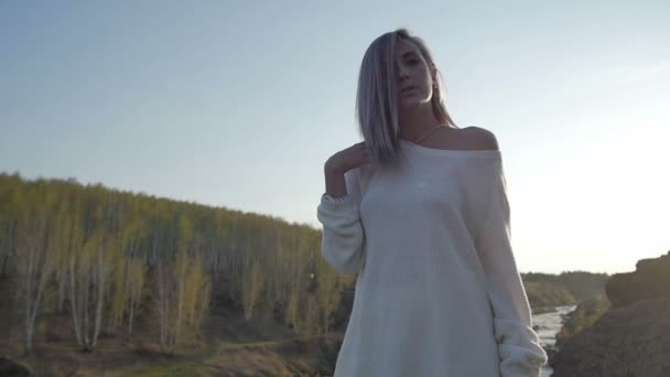 Mädchen steht auf einem Felsen auf dem Hintergrund des Flusses — Stockvideo