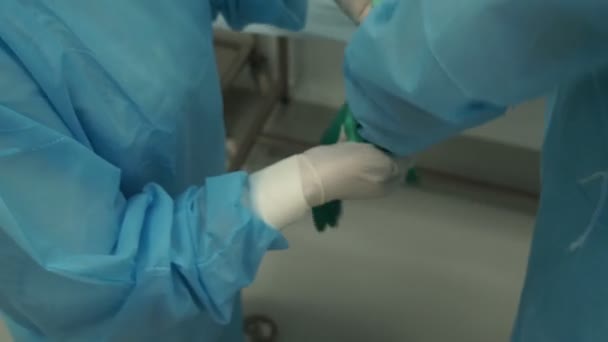 Un cirujano que se prepara para la cirugía se pone guantes — Vídeos de Stock