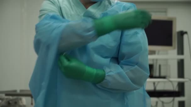 男性外科医は、手術後の手袋とガウンを削除します。 — ストック動画