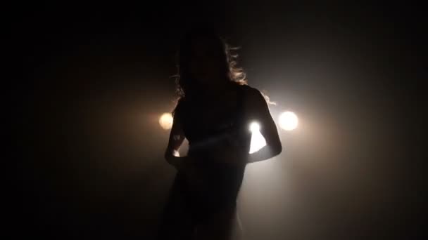 Silhouette d'une fille dansant sur les lumières de fond 