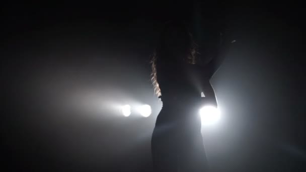 Silhouette di una ragazza che balla sulle luci di sfondo — Video Stock