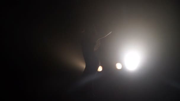 Silhouette d'une fille dansant sur les lumières de fond 