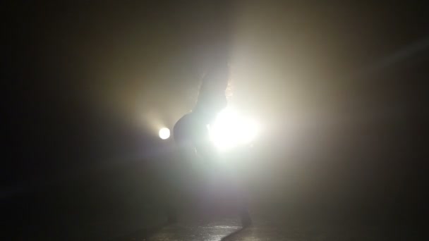 Silhouette d'une fille dansant sur les lumières de fond. Mouvement lent — Video