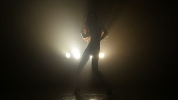 Silhouet van een meisje dansen op de achtergrond-verlichting. Slow motion — Stockvideo