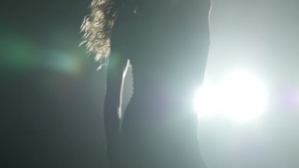 Silhouette d'une fille dansant sur les lumières de fond. Mouvement lent 