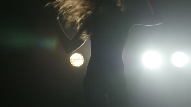 Silueta de una chica bailando en las luces de fondo. Movimiento lento — Vídeo de stock