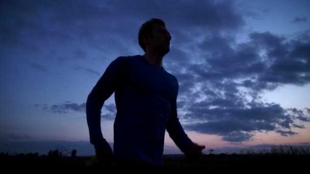 Yolda günbatımında koşan bir adam silüeti — Stok video
