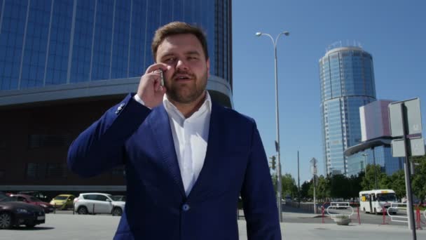 Άνθρωπος των επιχειρήσεων σε μπλε κοστούμι μιλάτε στο τηλέφωνο στο δρόμο. 4k — Αρχείο Βίντεο