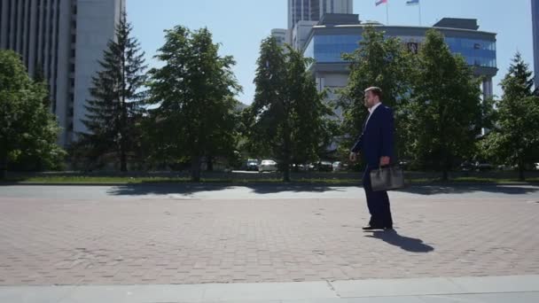 Empresario caminando por la calle para trabajar. Movimiento lento — Vídeo de stock