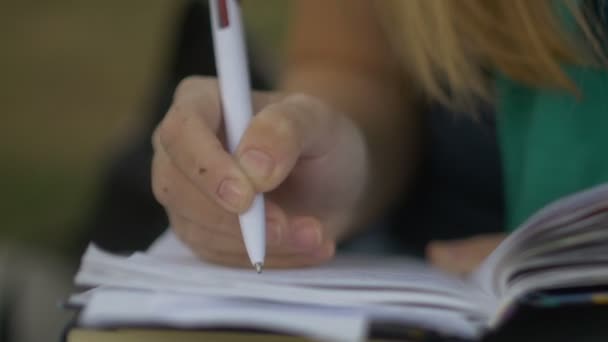 Studenten gör anteckningar i en anteckningsbok — Stockvideo