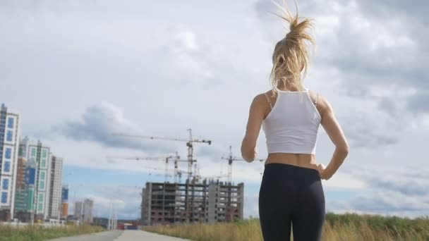 Chica corriendo en el fondo de las casas — Vídeo de stock