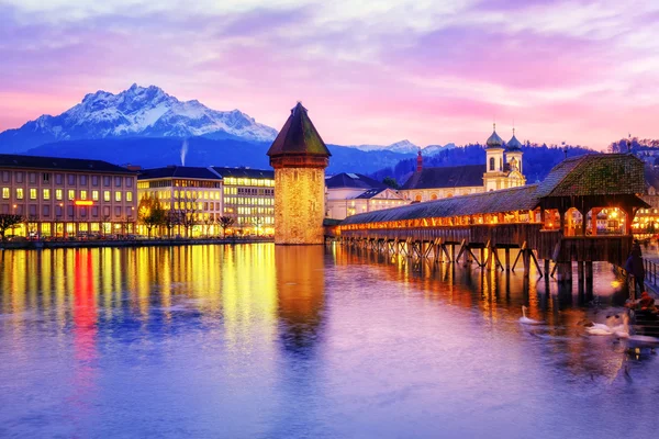 Puente de la capilla, torre de agua y monte Pilatus al atardecer, Lucerna, Suiza — Foto de Stock