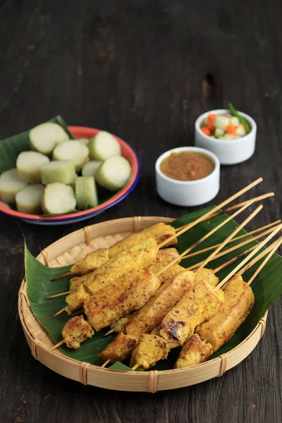 Close Up Sate Ayam Bumbu Kuning or Chicken Satay with Turmeric Spice, Served with Lontong 