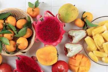 Top View Çeşitli Tropikal Meyveler, Ejderha Meyvesi, Mango, Jackfruit, Mandarin Portakalı ve Beyaz Tahta Masa 'da Kırmızı Gül Elması 