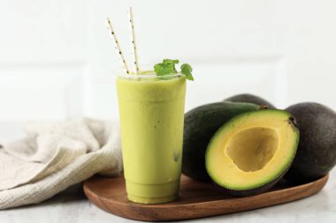 Plastik Kupa 'da karıştırılmış Avokado Suyu, Tahta Masanın Üzerinde Kağıt Kamış