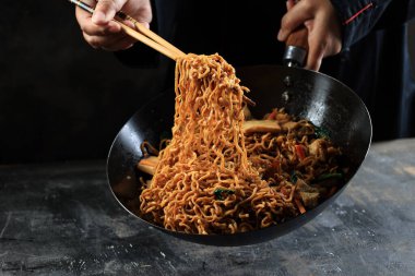 Şef Çin Lokantasında Kızarmış Erişte Pişiriyor Chopstick kullanarak, Mie Goreng Asya Fast Food Sebze ve Hamur köftesi ile