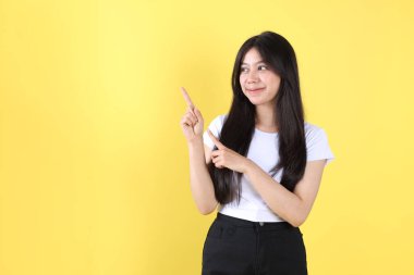 Uzun siyah saçlı Asyalı kadın sağ tarafa doğru işaret ediyor.
