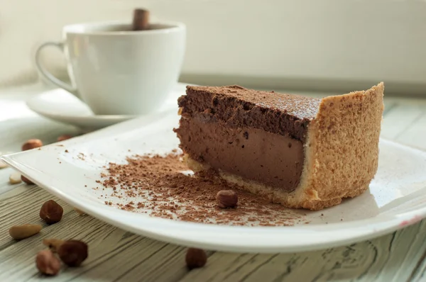 Una composición con una taza de café negro y la paz de un pastel de queso de chocolate —  Fotos de Stock