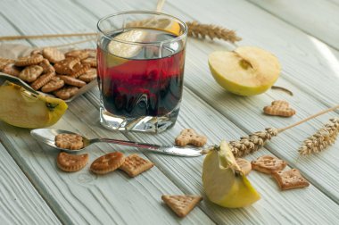 Bir bardak meyve içki (suyu), creckers, taze elma ve limon
