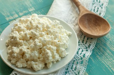 Süzme peynir bir ahşap yüzey üzerinde beyaz bir tabak içinde 