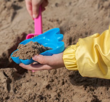 Bir kum kum ile oynayan çocuk eller