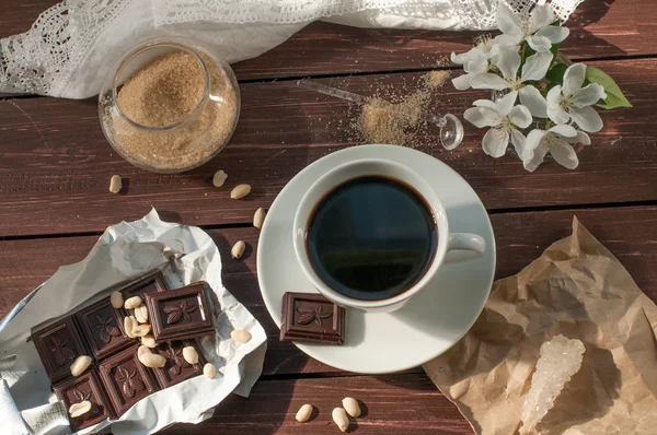 Komposisi dengan secangkir kopi, coklat bar dan ranting mekar dari pohon apel — Stok Foto