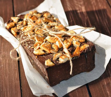 İştah açıcı bir çikolatalı kek bisküvi küçük parçalar ile dekore edilmiş ve rustik bir gazetede dedim yerleştirilir