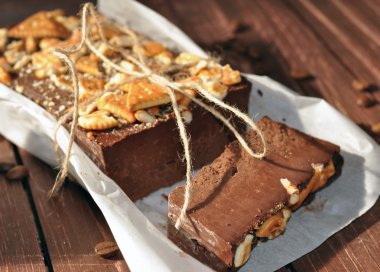 İştah açıcı bir çikolatalı kek bisküvi küçük parçalar ile dekore edilmiş ve rustik bir gazetede dedim yerleştirilir