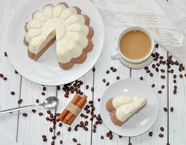 Bir iştah açıcı köpük Katmanı (vanilya ve çikolata) kek ve bir ahşap yüzey üzerinde süt kahve ile bir yemek