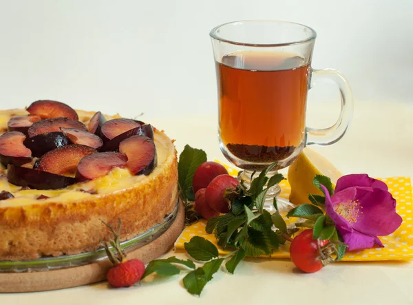Un pastel de frutas, una taza de té, una rosa de perro fresca y caderas —  Fotos de Stock