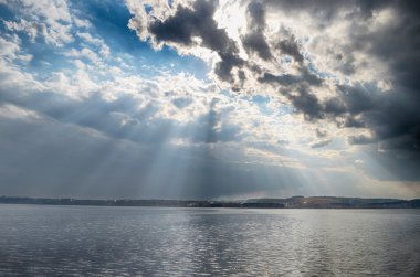 Bulutların arasından parlayan güneş ışınlarının.