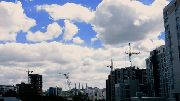 Баштові крани на тлі хмар у місті — стокове відео