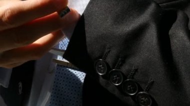 Adam kol düğmesi giyer