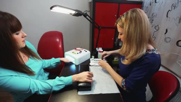 Mädchen trocknet den Nagellack in UV-Lampe — Stockvideo