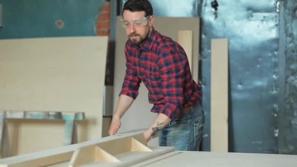 Homme sciant une planche dans un atelier de menuiserie à l'aide d'une scie circulaire — Video