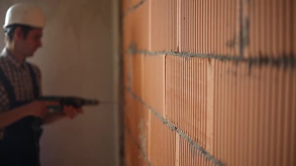 Werknemer boren gat in de muur bokeh — Stockvideo