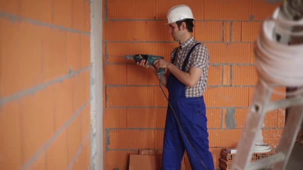 L'électricien effectue une installation électrique à l'aide d'une perceuse — Video