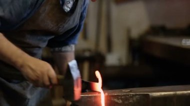 Demirci örs üzerinde metal uydurandan