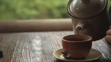 Eller kızlar çay döktü ve onun elinde Kupası aldı