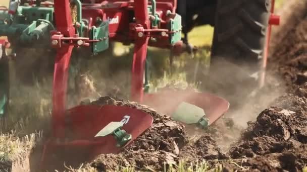 Traktor med plogen plöjer marken — Stockvideo