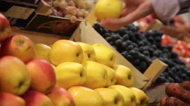 Alıcı piyasada elma seçer ve sepete ekler