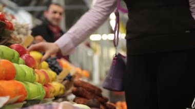 Alıcı piyasada elma seçer ve sepete ekler