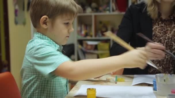 Niños pintan con pincel sobre papel — Vídeo de stock