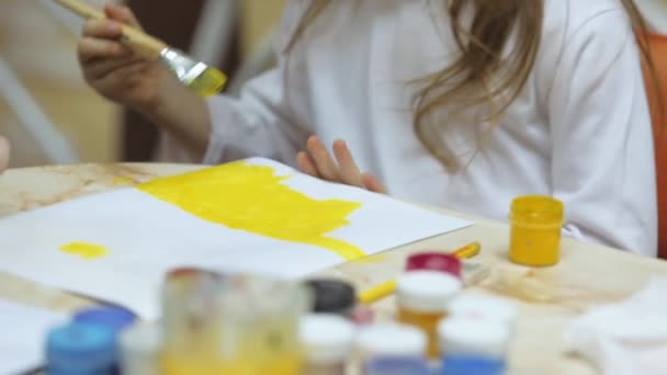 Девушка рисует краски на бумаге — стоковое видео