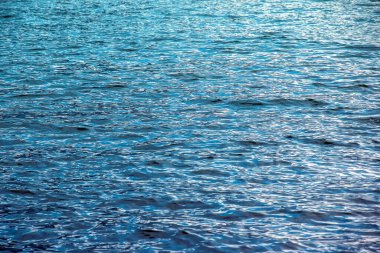 Alplerdeki Traunsee Gölü 'nün su arka planı. Berrak bir dağ gölünün yansımalarının renkli dokusu. Yansımalı su dokusu.