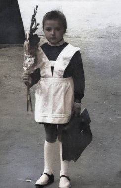 Elinde bir buket çiçek ve okul çantası olan resmi okul üniformalı bir birinci sınıf öğrencisinin retro portresi. 1974 'ten kalma eski bir fotoğraf..