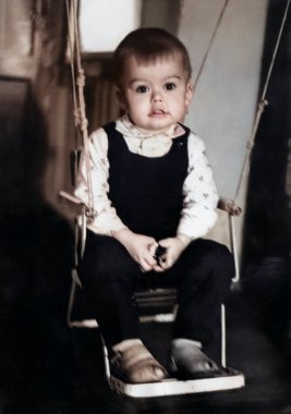 Kapının önüne konmuş salıncakta sallanan bir çocuğun klasik portresi. Fotoğraf: 1969.