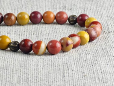 Çuval bezi arka planında mukait jasper 'dan yapılmış dua boncukları. Yakın plan. Ayrıntılar. Seçici odak.