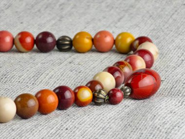 Çuval bezi arka planında mukait jasper 'dan yapılmış boncuklar. 33 boncuklu tespih, çeşitli inançlara sahip insanlar tarafından geleneksel olarak meditasyon için kullanılır..