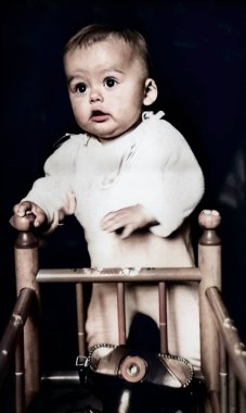 Beşiğinde duran küçük bir çocuğun klasik portresi. Çantasındaki kamera beşiğinde duruyor. 1968 'den eski bir fotoğraf.